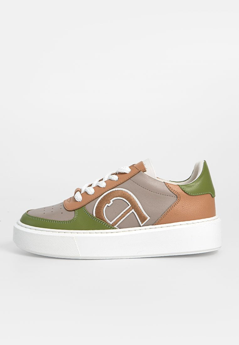 Niedrig geschnittener Sneaker mit weißer Sohle, grünen, beige und braunen Lederpanelen, weißen Schnürsenkeln und einem großen bestickten "a" an der Seite.