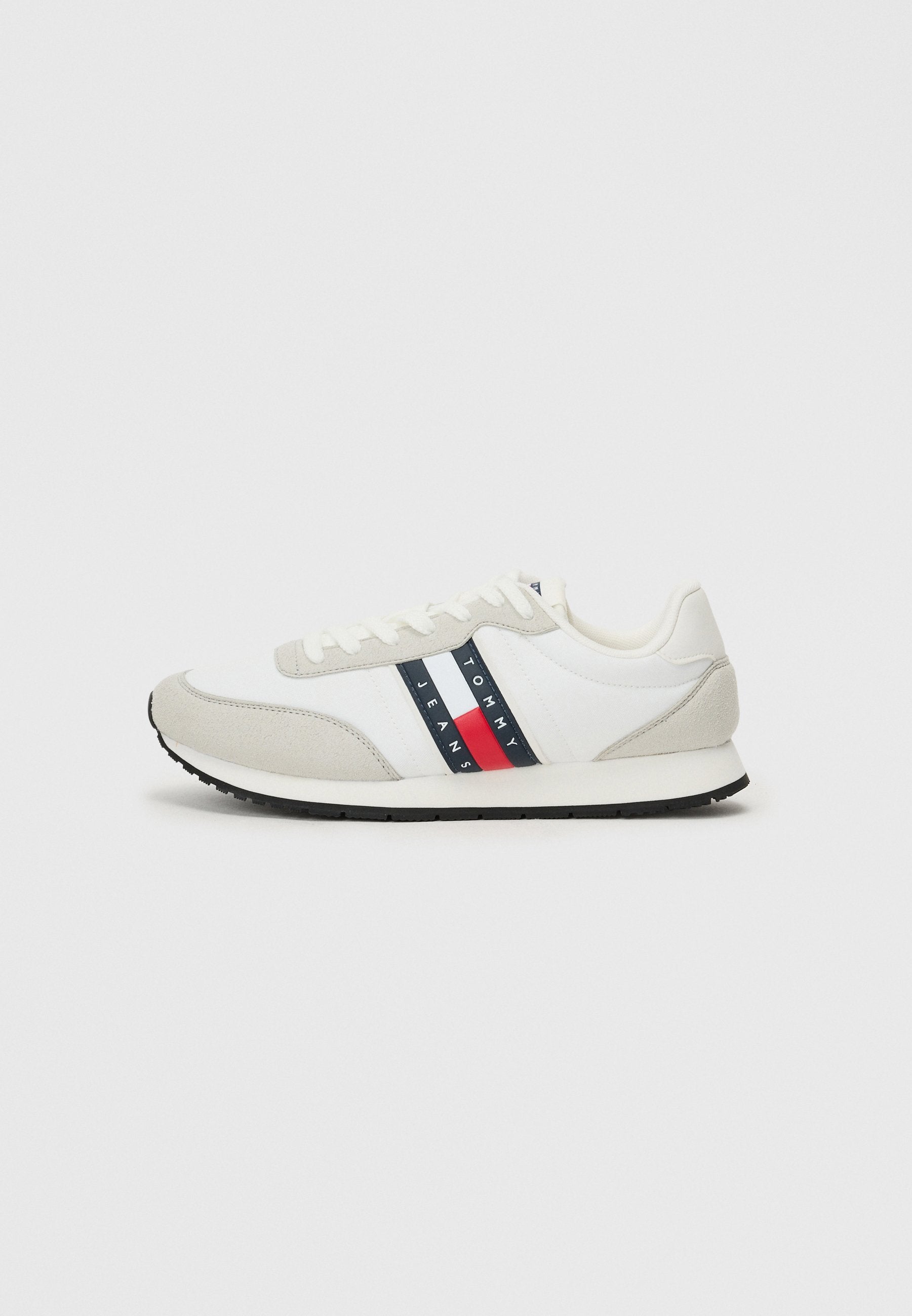 Männliche Laufschuhe mit einem weißen Stoffoberteil, grauen Wildlederakzenten, einer schwarzen Gummisohle und einem rot-blauen gestreiften Logodesign.