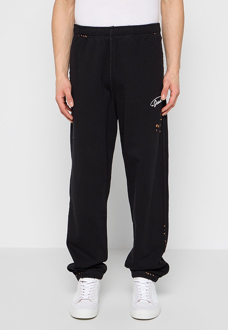 Schwarze Sweatpants mit elastischem Bund, Seitentaschen und Logodetails. Verfügt über abgenutzte Akzente und eine entspannte Passform.