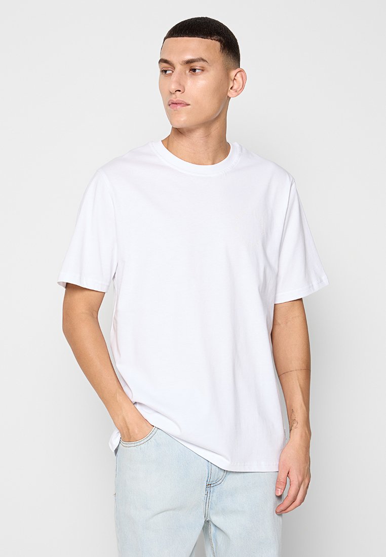 Weißes Baumwoll-T-Shirt mit Rundhalsausschnitt und kurzen Ärmeln. Der Stoff ist glatt und das Design ist einfach, ohne sichtbare Muster oder Logos.