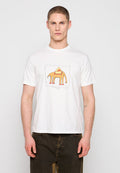 Junger Mann trägt ein weißes T-Shirt mit einem orangefarbenen Elefantengrafik und dunklen Hosen, steht vor einem einfarbigen hellen Hintergrund.