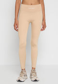 Beige aktive Leggings mit hohem Bund, ausgestattet mit dezenten Nähten und einem weißen "PEGADOR" Logo oben. Weiches, dehnbares Material.
