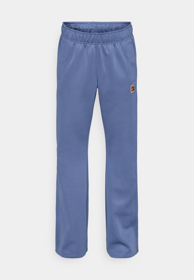 Blaue Jogginghose mit elastischem Bund, Seitentaschen und einem kleinen, mehrfarbigen Logopatch nahe der linken Tasche. Weicher Stoff.