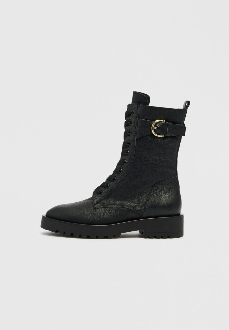 Schwarze Leder-Schnürstiefeletten mit rundem Zeh, robuster Sohle und goldenem Schmuckdetail an der Seite. Strukturierte Oberflächenoptik.