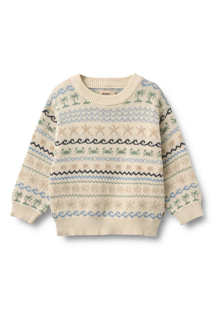 Gestrickter Pullover in Creme mit blauen, grünen und schwarzen Mustern, darunter Wellen, Bäume und Sterne. Rundhalsausschnitt und gerippte Bündchen.