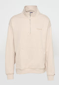 Beiger Pullover mit langen Ärmeln, Halbreißverschluss am Kragen, Kängurutasche, gerippten Bündchen und dezentem "tommyjeans"-Logo auf der linken Brust.