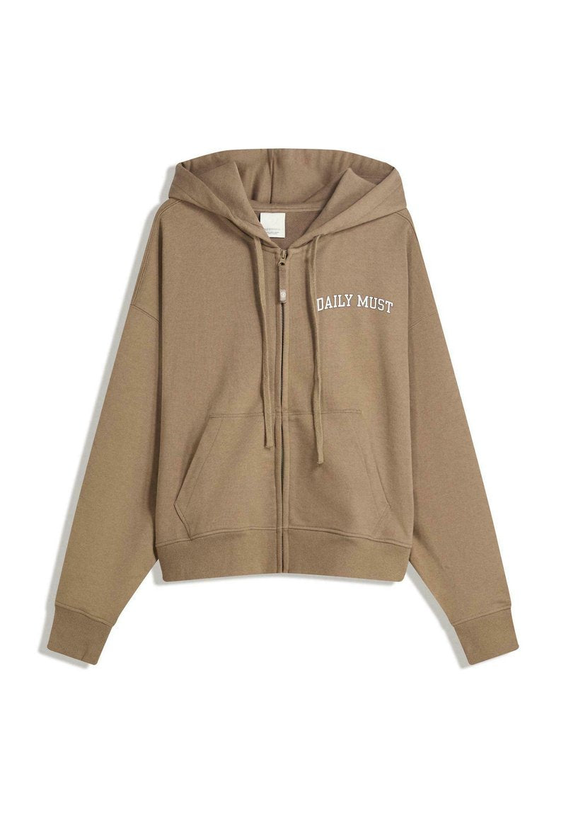 Brauner Kapuzenpullover mit Reißverschluss, großen Fronttaschen und dem Text "DAILY MUST" in weißer Stickerei auf der linken Seite. Weiches Stoffgefühl.