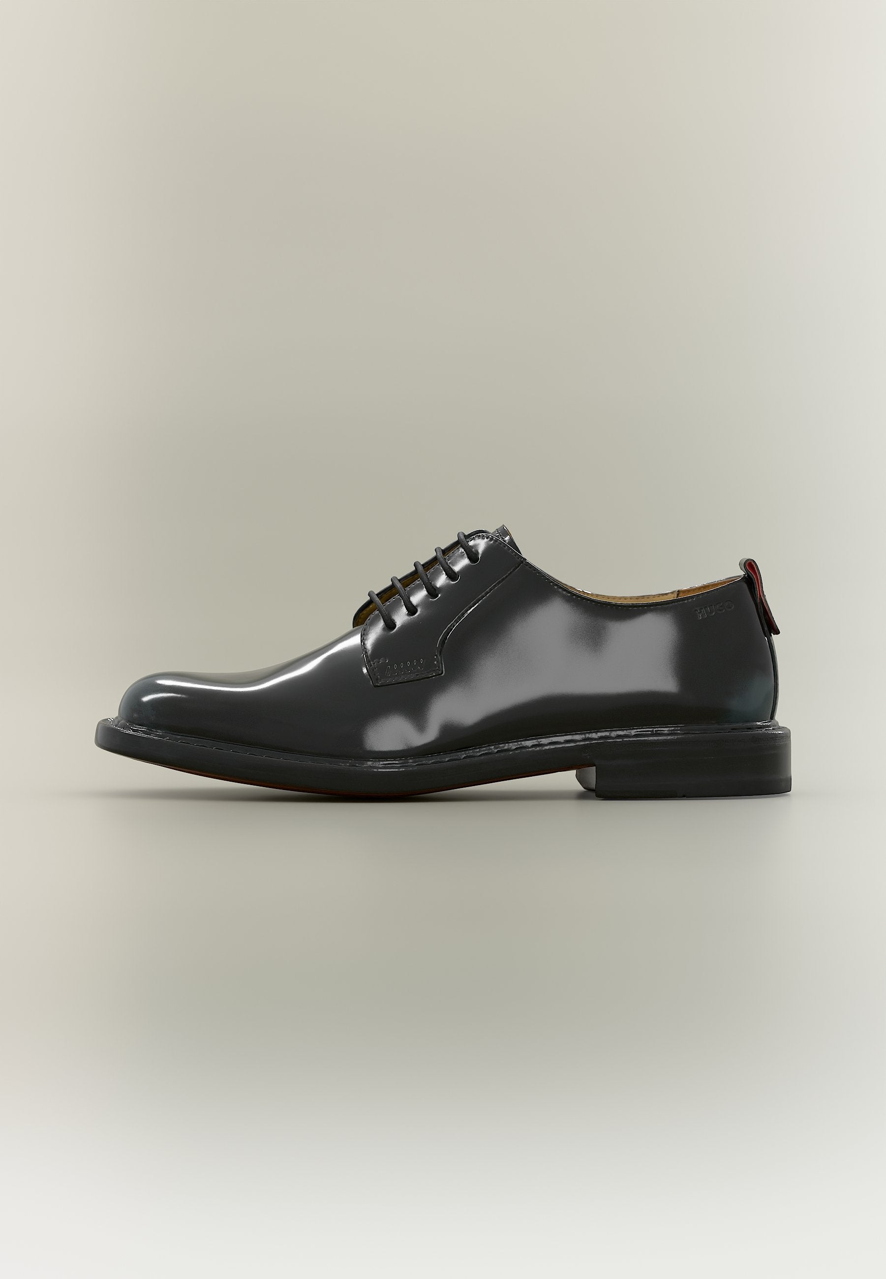 Glänzender schwarzer Leder-Derby-Schuh mit flachem Absatz und rundem Zehenbereich, seitlich auf neutralem Hintergrund dargestellt.