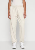 Hellbeige Baumwoll-Sweatpants mit elastischem Bund und schmal zulaufenden Beinabschlüssen, die eine weiche Textur und eine lockere Passform aufweisen.