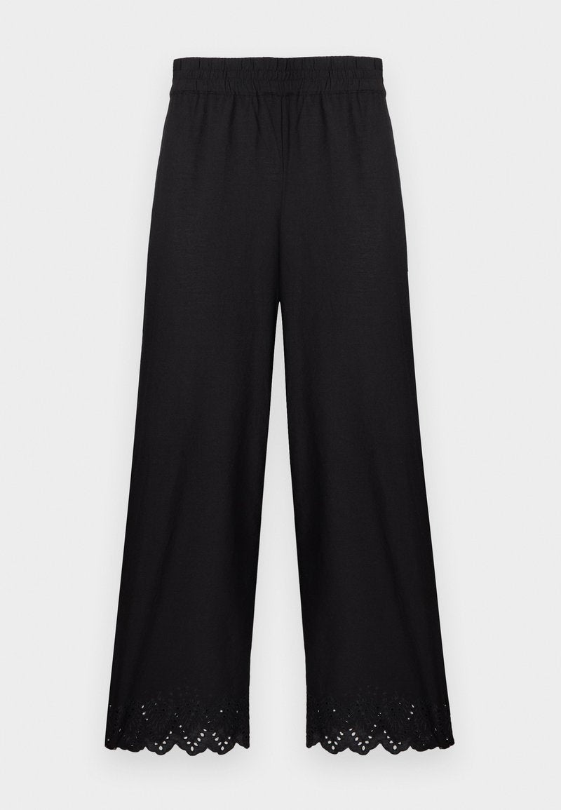 Schwarze weit geschnittene Hose mit elastischem Bund und gezacktem Spitzenbesatz am Saum, auf hellem einfarbigem Hintergrund dargestellt.