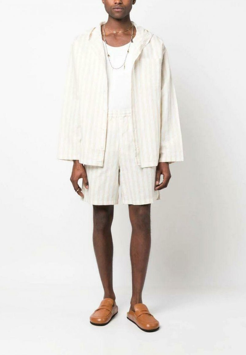 Hellblau gestreiftes Hemd mit Jacken- und passender Shorts in Beige und Creme. Flache braune Slippers. Einfaches Tanktop darunter. Minimalistisches Design.