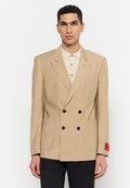 Beige, doppelt geknöpfter Blazer mit zwei großen Taschen, schwarzen Knöpfen und einem roten Etikett am Ärmel. Strukturierte, maßgeschneiderte Gestaltung und klar definierte Form.