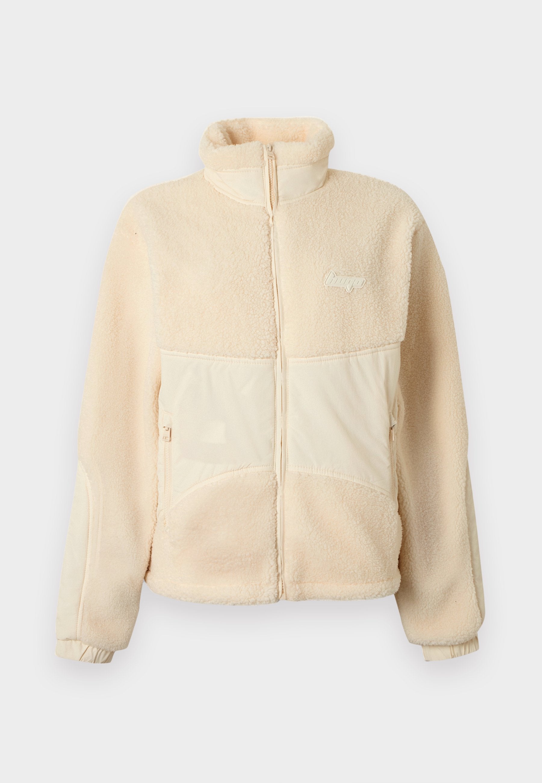 Beige Fleecejacke mit Reißverschluss, Stehkragen, zwei vorderen Reißverschlusstaschen, elastischen Bündchen und kleinem Logo auf der linken Brust.