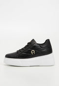 Schwarze Plattform-Sneaker aus glattem Leder, mit gesteppter Gestaltung, runder Zehenpartie, weißer Sohle und einem goldenen Akzent-Logo an der Seite.
