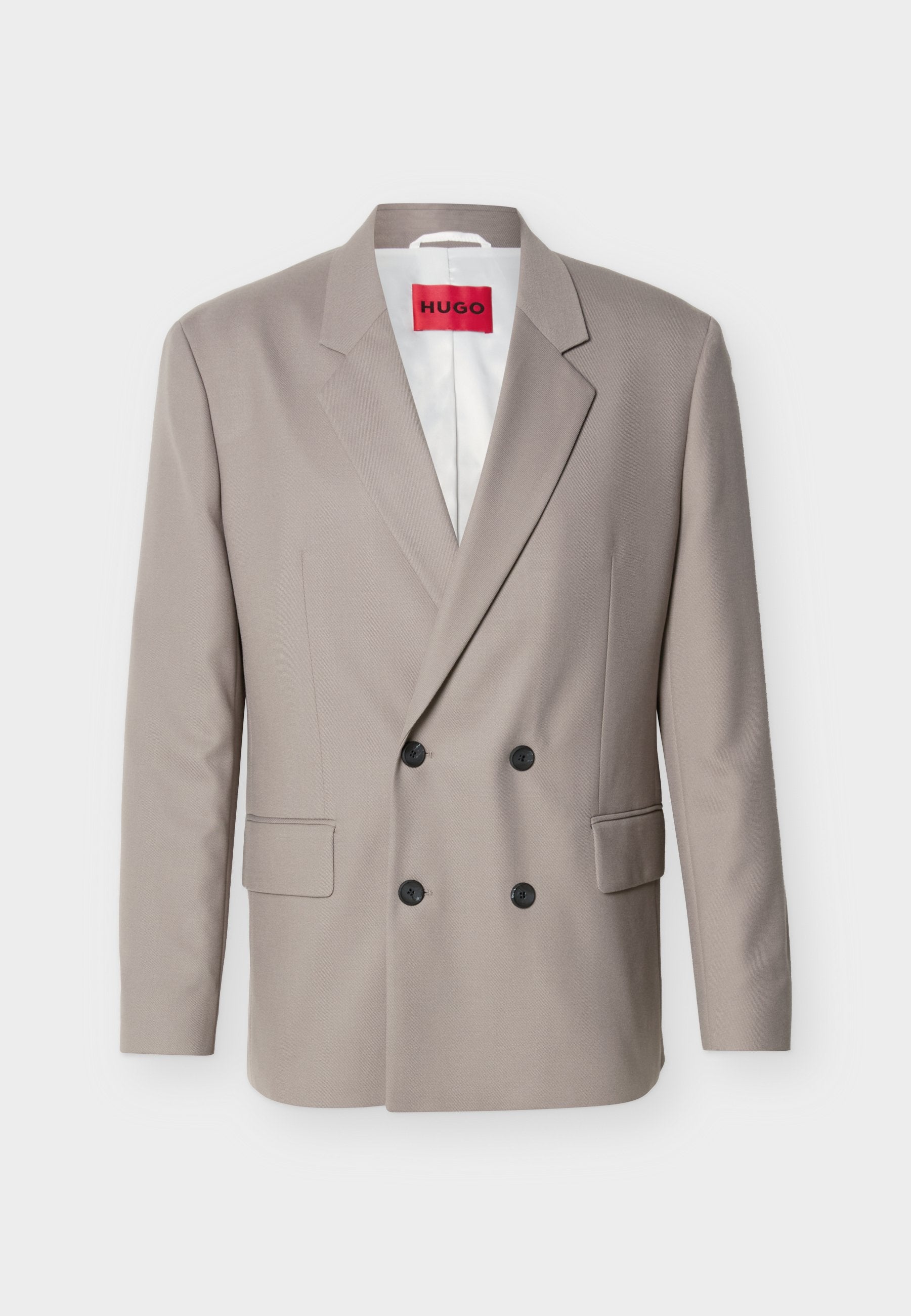 Hellbeiger zweireihiger Blazer mit schwarzen Knöpfen, nichtched Revers, Pattentaschen und rotem HUGO-Label auf weißem Innenfutter.