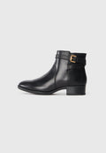 Schwarze Leder-Ankle-Boots mit glatter Oberfläche, strukturiertem Rückenteil und einem dekorativen Riemen mit goldener Schnalle. Niedriger Absatz.