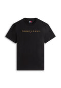 Schwarzes T-Shirt mit kurzen Ärmeln und der Aufschrift "TOMMY JEANS" in goldenen Buchstaben sowie einem kleinen roten, weißen und blauen Tommy Hilfiger-Logo unter dem Text.