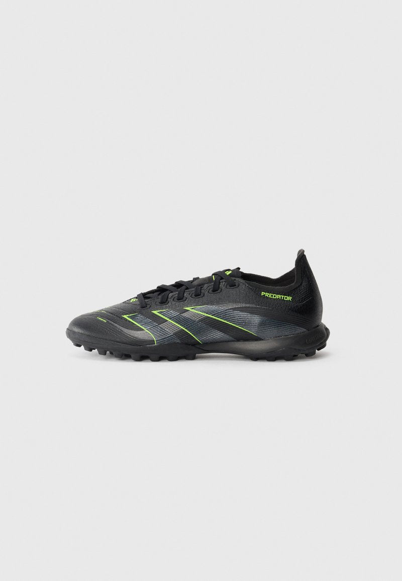 Schwarzer und grauer Fußballschuh mit limettem grünen Akzenten, Schnürsenkeln und strukturierten Sohlen, designed für den Einsatz auf Kunstrasen oder festem Untergrund.