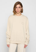 Beige übergroßes Sweatshirt, runder Ausschnitt, lange Ärmel, weicher Stoff, mit einem kleinen runden Logo auf der Brust, gerippten Bündchen und Saum.