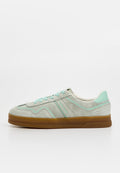 Helle graue Wildleder-Sneaker mit mintgrünen Akzenten, runder Zehenpartie, Schnürung und einer Sohle aus Gummi. Dezente dekorative Nähte.