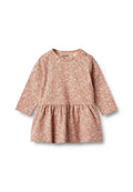 Langärmliges Kleid aus weichem rosa Stoff mit floralem Muster. Verfügt über einen runden Halsausschnitt und einen gerafften Rock mit einem Knopfdetail an der Schulter.