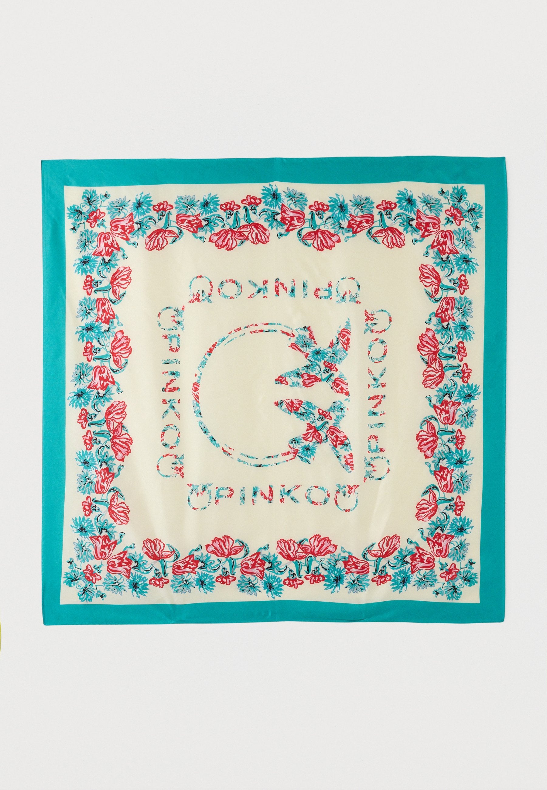 Quadratischer cremefarbener Schal mit türkisfarbenem Rand, rot-blauem Blumenmuster an den Rändern und zentralen stilisierten Buchstaben, die ein kreisförmiges Design bilden.