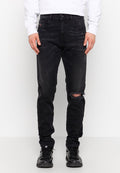 Schwarze Jeans aus Denim in Slim Fit, mit einem zerrissenen Knie, fünf Taschen und einem Knopfverschluss. Getragen mit einem weißen Sweatshirt und schwarzen Turnschuhen.