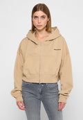 Beige Crop-Hoodie aus weichem Stoff mit Reißverschluss, Fronttaschen und schwarzem "PEGADOR"-Logo auf der linken Brust.