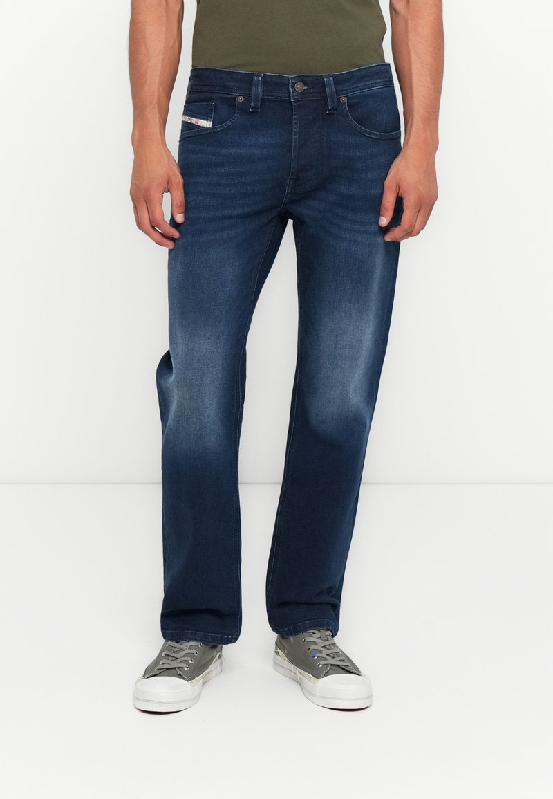 Dunkelblaue Jeans im geraden Schnitt mit fünf Taschen und dezentem Verblassen an den Knien. Akzentuiert mit einem Metallknopf.