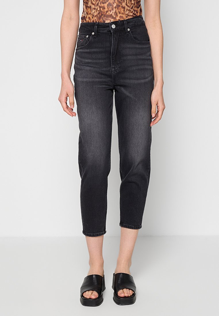 Schwarze hoch taillierte Cropped-Jeans mit leichtem Ausbleichen, getragen mit schwarzen offenen Slide-Sandalen und einem braunen Oberteil mit Animal-Print.
