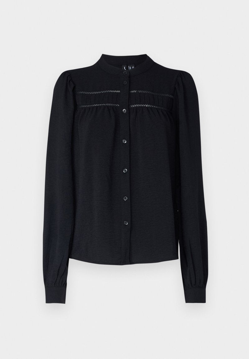 Schwarze Bluse mit langen Ärmeln, kragenloser Halsöffnung, Knopfleiste, plissierten Details unter dem Schulterbereich und gerafften Manschetten. Weicher, strukturierter Stoff.