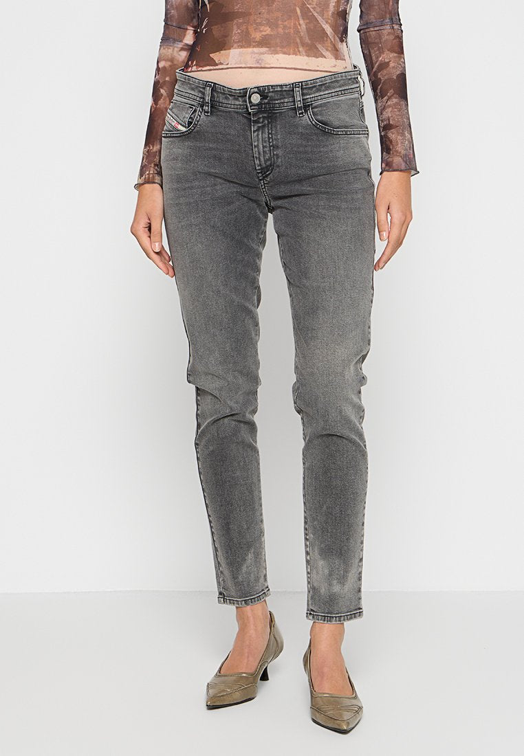 Graue Skinny-Jeans aus Denim mit einem ausgeblichenen Finish, ausgestattet mit fünf Taschen, Gürtelschlaufen und einem klassischen Knopfverschluss. Kombiniert mit metallischen High Heels.