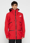 Rote wasserdichte Jacke mit hohem Kragen, mehreren Reißverschlusstaschen und schwarzen Akzenten. Hergestellt aus strukturiertem Material mit Kapuze.
