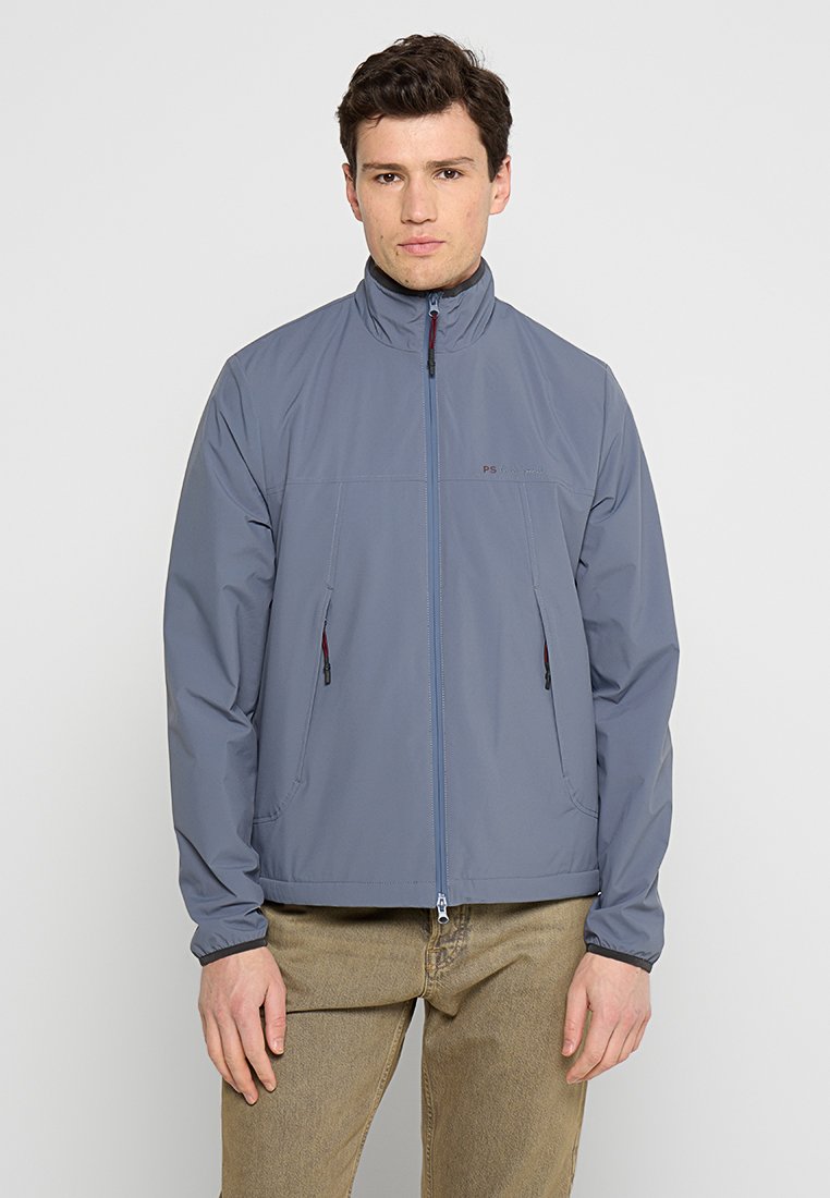 Leichte graue Jacke mit hohem Kragen, Frontreißverschluss und zwei Seitentaschen. Sie verfügt über dezente Markenkennzeichnung und eine glatte, matte Textur.