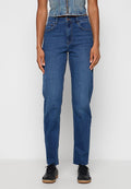 Person, der hoch taillierte, gerade geschnittene blaue Jeans, schwarze Sneakers und ein ärmelloses Denim-Crop-Top mit Frontreißverschluss trägt.