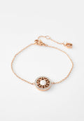 Zartes Armband aus Roségold mit einem runden Anhänger, der eine zentrale Perle, ein filigranes Cut-out-Design und umliegende kleine Kristalle aufweist.