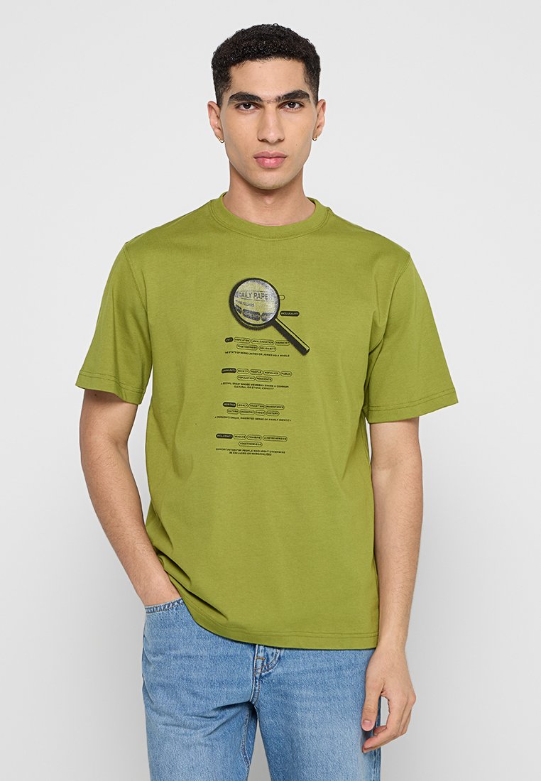 Olivegrünes T-Shirt mit kurzen Ärmeln aus Baumwolle, das eine Lupe mit schwarzem Text darüber und darunter zeigt.