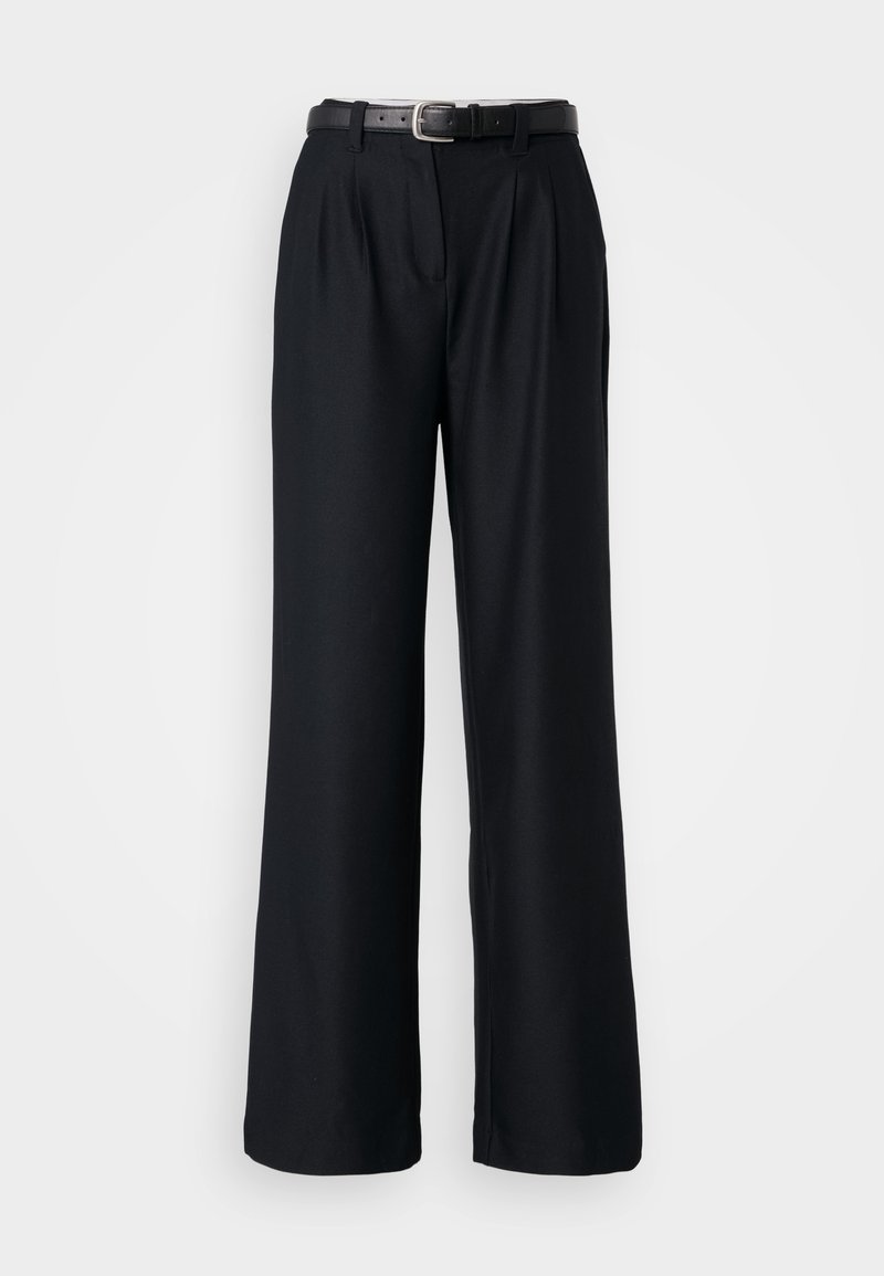 Schwarze weit geschnittene Hose aus glattem Stoff, mit vorderen Falten und einem passenden schwarzen Gürtel mit einer silbernen Schnalle.