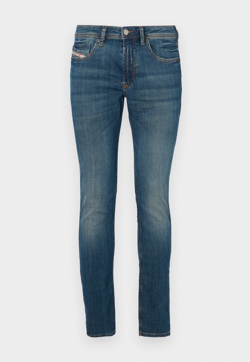 Blaue Denim-Jeans im Slim-Fit, mit einem Knopfverschluss, klassischem Fünf-Taschen-Design und leichten Abnutzungserscheinungen an den Beinen für einen getragenen Look.