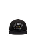 Schwarze Kappe mit flachem Schirm, mit weißem gesticktem Text: "LES DEUX EST. 2011" und "International Sporting Goods." Glatte Stofftextur.