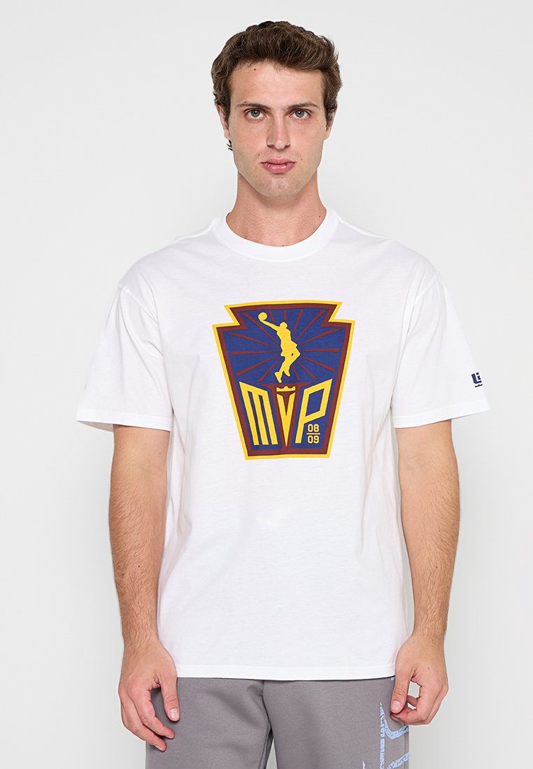 Mann in weißem T-Shirt mit blau-gelbem MVP Basketball-Logo und grauen Shorts vor weißem Hintergrund.