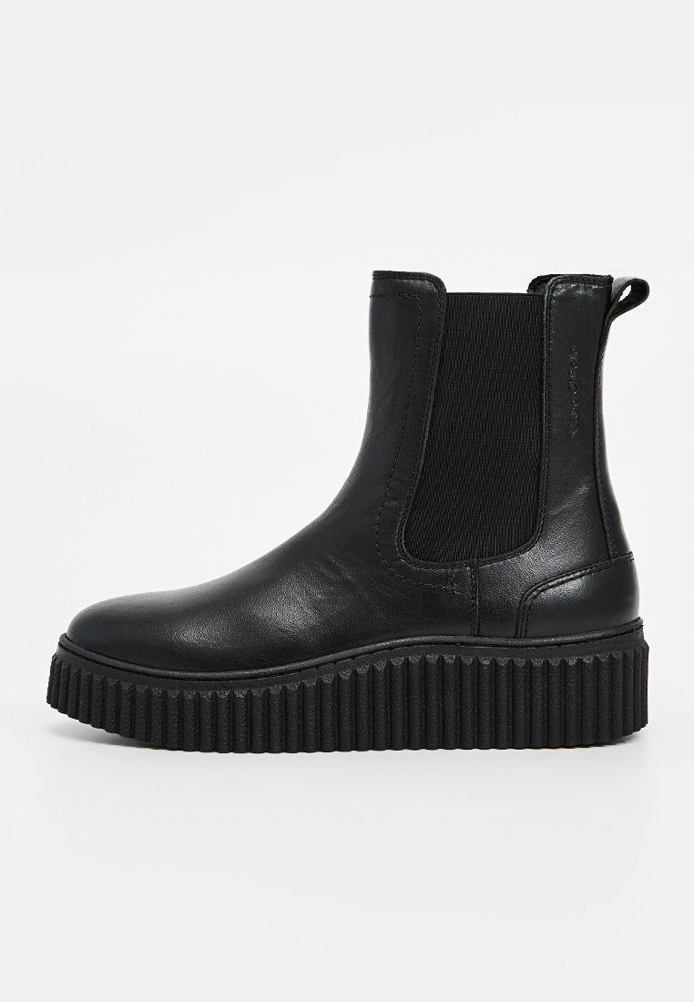 Schwarze Leder-Stiefeletten mit elastischen Seiteneinsätzen, einer strukturierten Gummisohle und einem runden Zehenbereich, der über gerippte Details auf der Sohle verfügt.
