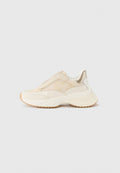 Beige Netz-Sneaker mit strukturiertem Obermaterial, elastischem Schlupf-Design und einer klobigen weißen Außensohle. Mit goldfarbenen Akzenten und einem Logo versehen.