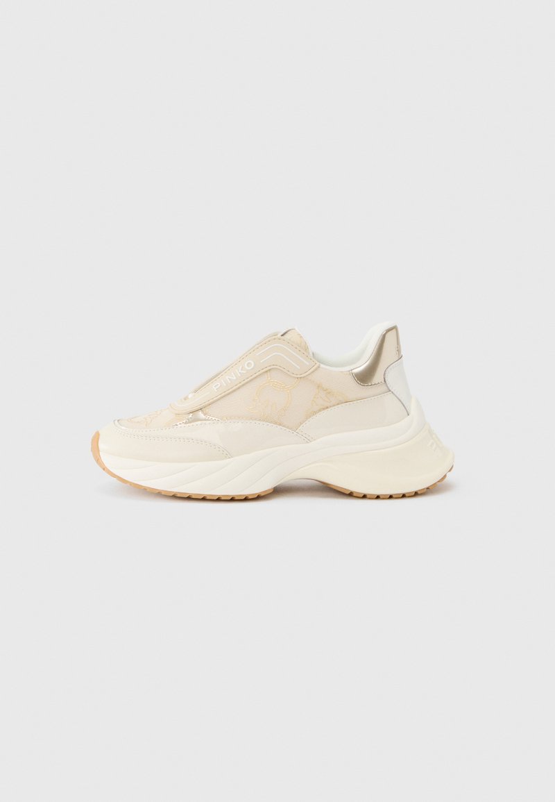 Beige Netz-Sneaker mit strukturiertem Obermaterial, elastischem Schlupf-Design und einer klobigen weißen Außensohle. Mit goldfarbenen Akzenten und einem Logo versehen.