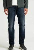 Dunkelblaue Jeans aus Denim mit leichter Ausbleichung, Slim-Fit-Design und klassischem Fünf-Taschen-Stil, kombiniert mit grauen Sportschuhen.