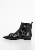 Schwarze Leder-Stiefelette mit spitzem Zehenbereich und vier silbernen Schnallenriemen an der Seite, flache Sohle und Ziehlasche hinten.