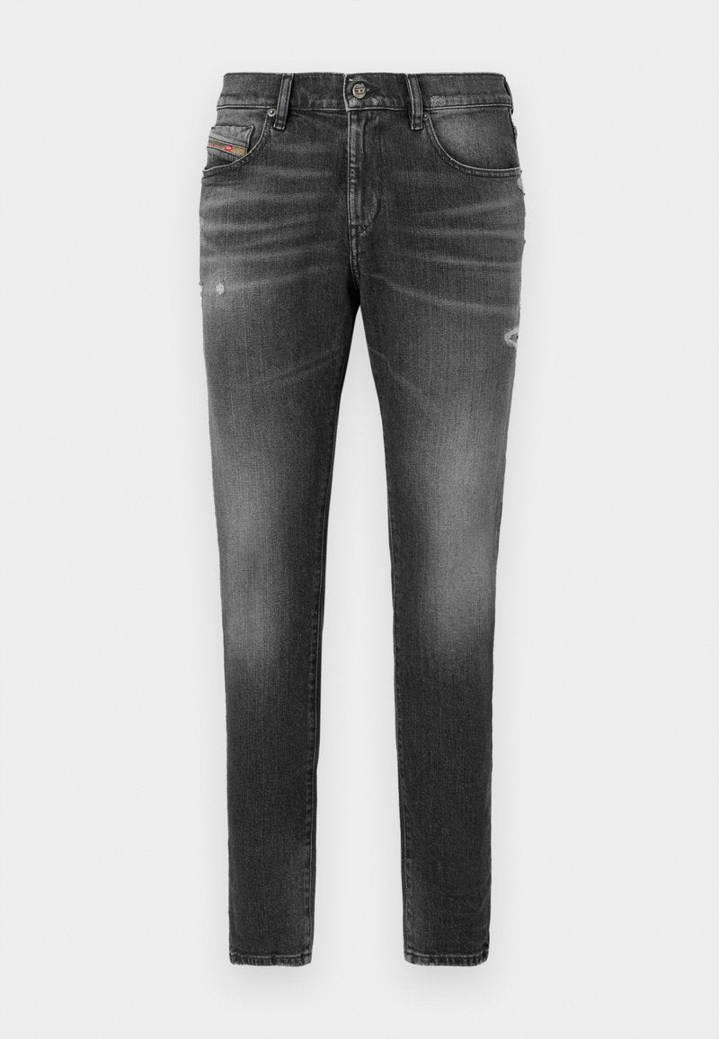 Graue Denim-Jeans mit schlankem Schnitt, die über leicht abgewetzte Bereiche, distressed Details und einen traditionellen Knopfverschluss verfügen.