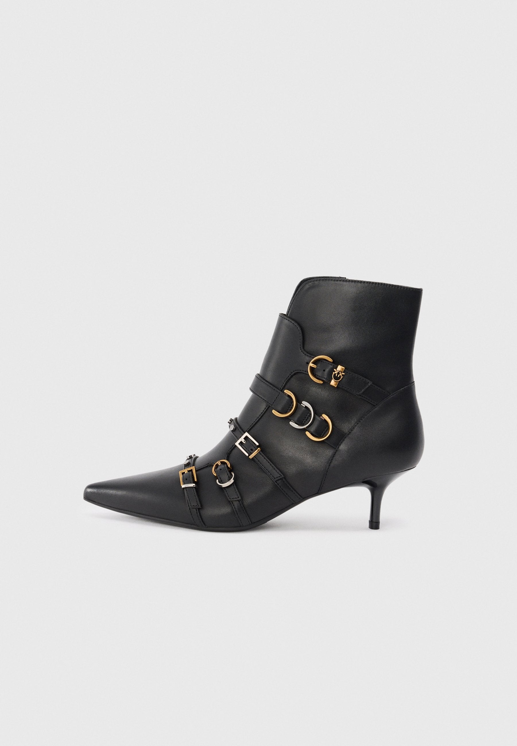 Schwarze Lederstiefelette mit spitzem Zehenbereich, ausgestattet mit goldenen und silbernen Hardware-Akzenten, verstellbaren Riemen und einem moderaten Absatz.
