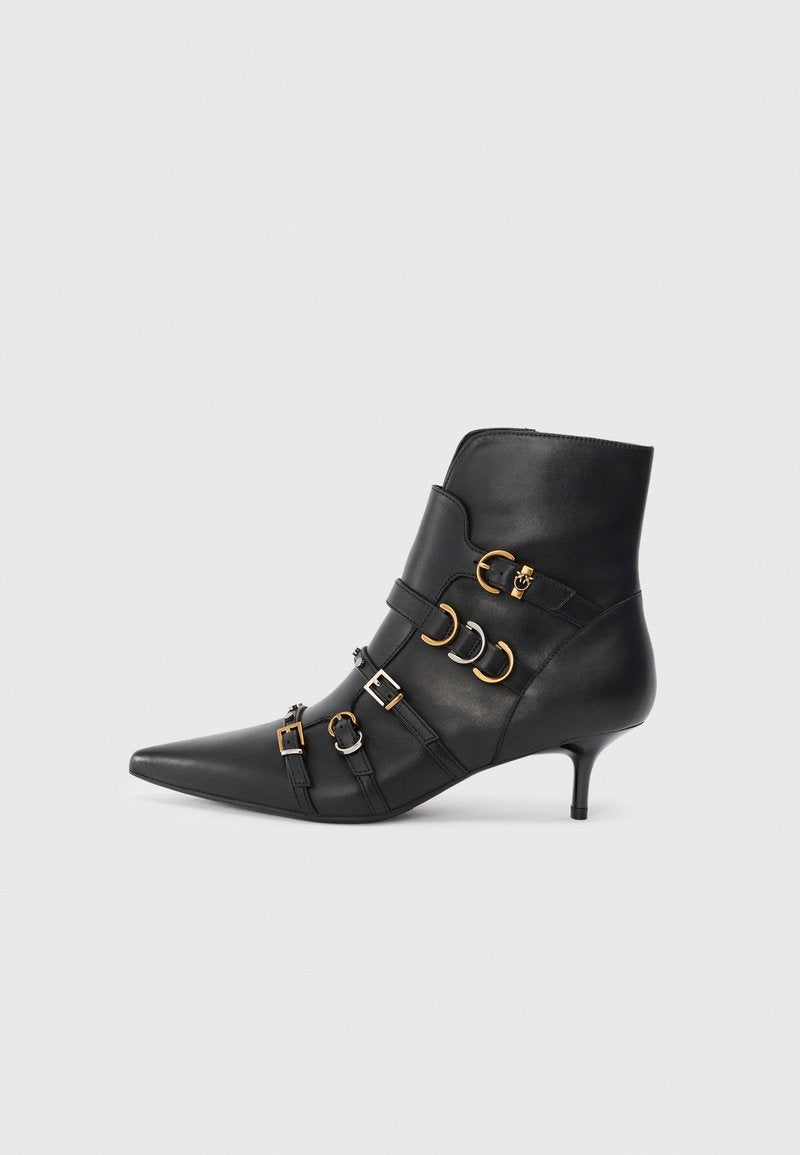 Schwarze Lederstiefelette mit spitzem Zehenbereich, ausgestattet mit goldenen und silbernen Hardware-Akzenten, verstellbaren Riemen und einem moderaten Absatz.