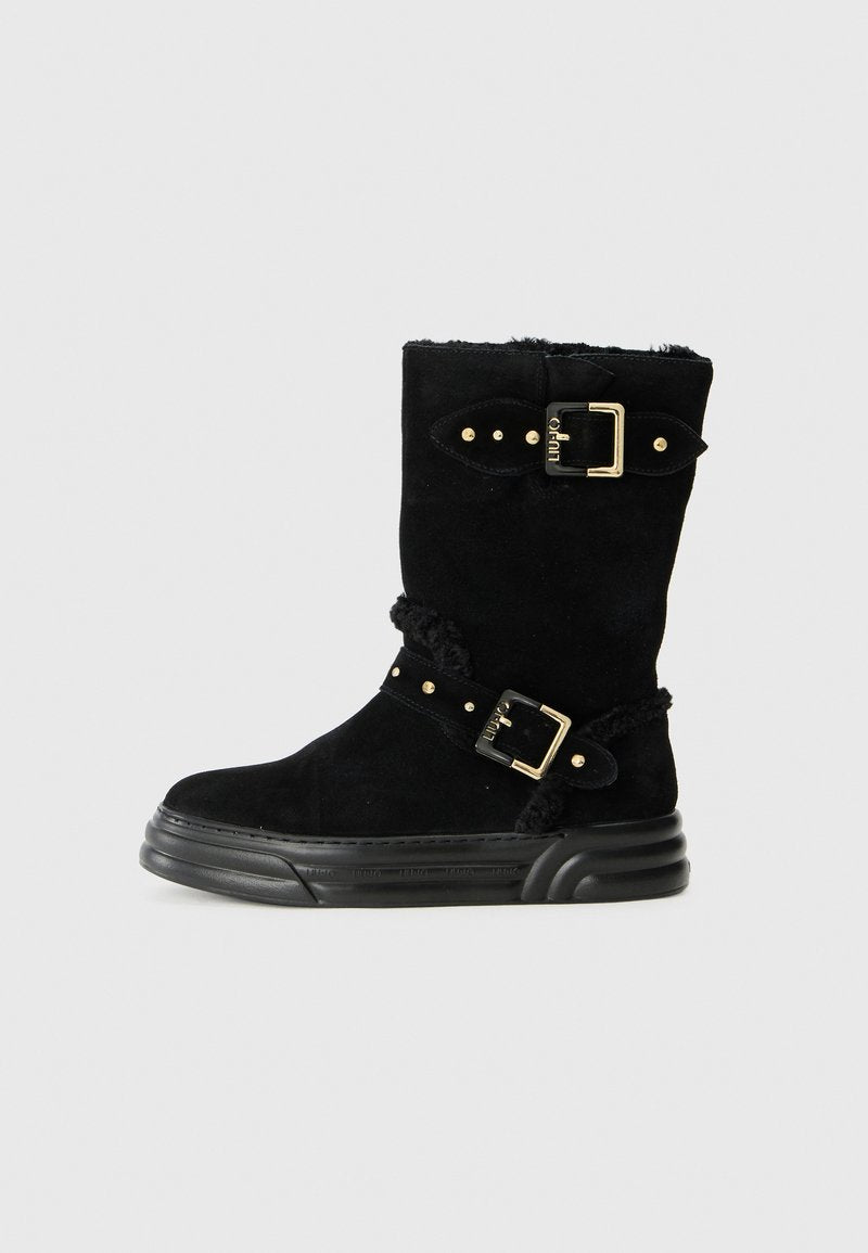 Schwarze Wildleder-Ankle-Boots mit zwei goldenen Schnallen, verziert mit Nieten, einem strukturierten Innensaum und einer dicke schwarzen Sohle.